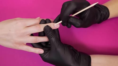 Maniküristengriffe Nagelhaut mit Holzstäbchen im Schönheitssalon, Damenmaniküre, gesunde Nägel
