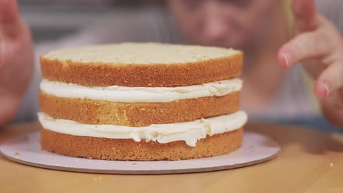 Der Konditor dreht den Kuchen um und untersucht ihn beim Kochen