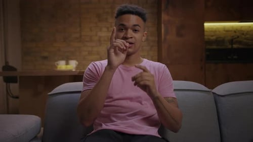 Young Adult Talking and Gesturing on a Sofa