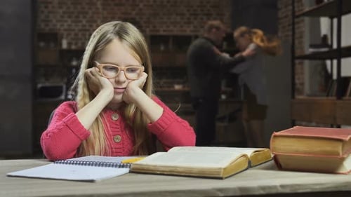 Chica molesta estudiando mientras sus padres pelean