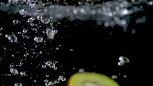 Slices of Kiwi Fruit Falling into Water
