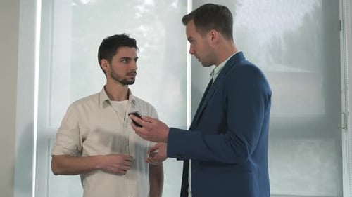Two Men Discussing Content on a Phone