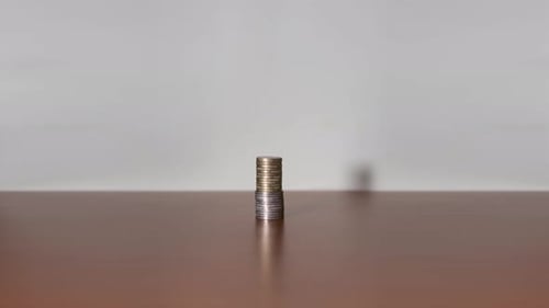 Tower of Coins Growing on Brown Table