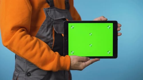Close Shot of Handyman Holding a Tablet with Green Screen.