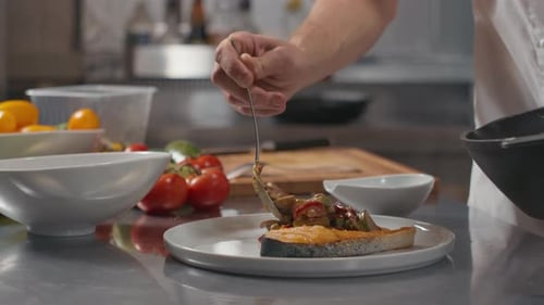 Chef Plates Gourmet Salmon Dish in Professional Kitchen