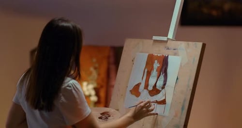 Young Woman Painting on Canvas in Studio