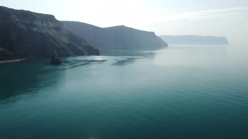 Luftbild von oben auf ruhiges azurblaues Meer und vulkanische Felsküsten
