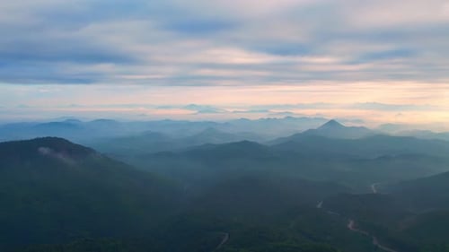 4K aerial view from a drone flying over the valley, fog in the morning.