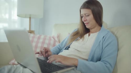 Woman Typing on Laptop at Home