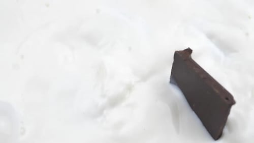 Chocolate Chunks Falling into Fresh, White Milk