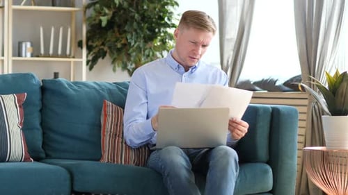 Focused Man Working on Laptop at Home