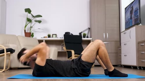 Man Doing Sit-Ups on Yoga Mat at Home