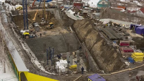 High Crane Works on Building Site with a House