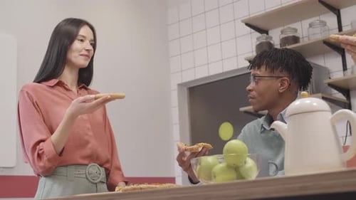 Coworkers Eating Pizza Together in Office Breakroom