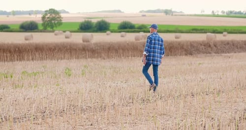 Farmer Using Digital Tablet While Examining Field