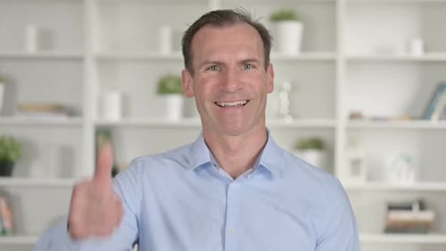 Man Smiling and Giving Thumbs Up Indoors