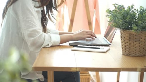Young Woman Working on Laptop and Writing Notes
