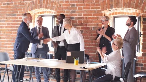 Group of Businessmen in Office Congratulate Colleague Who Sit at Table and Work To Laptop