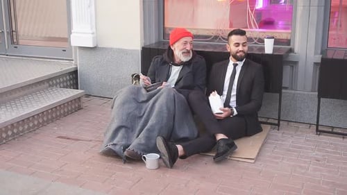 Smiling Rich and Poor Men Together Sitting on Street and Eat While Speaking.