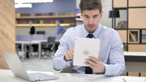 Distressed Man with Tablet in Modern Office