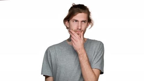 Retrato de un chico sin afeitar posando con una mirada concentrada y dudando o tratando de recordar aislado
