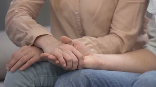 Jeune homme gardant la main de sa petite amie et tenant le préservatif, contrôle de la couchette, prévention