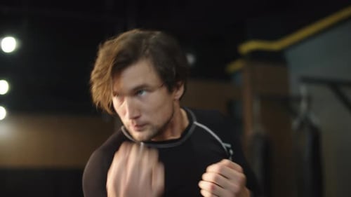Aggressive Boxer Practicing Beats in Sport Club. Male Athlete Training at Gym