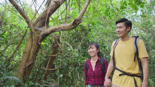 Young Asian man and woman friend traveling in the forest together feeling fresh and relax.