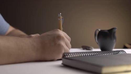 Close up of person writing in black notebook