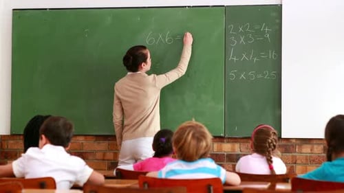 Jolie prof enseignant les maths à sa classe et souriant à la caméra