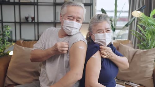 Senior Couple Displays Bandages After Receiving Vaccinations