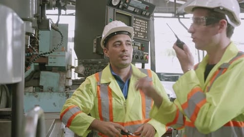 Factory Workers Observing Industrial Machine Operations