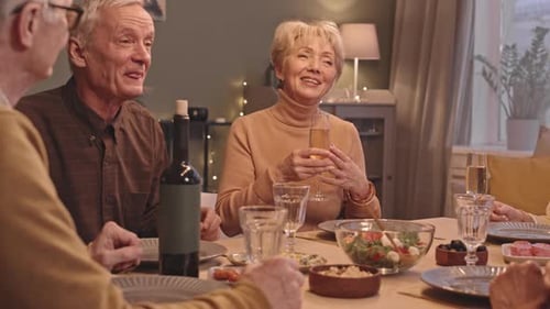 Seniors Laughing and Celebrating Together at Dinner