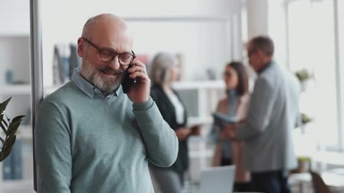 Senior Businessman Speaking on Cell Phone in Office