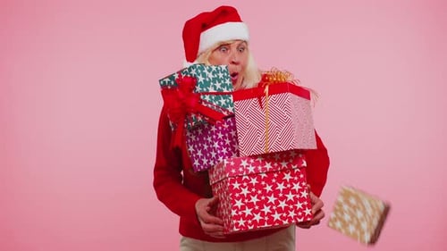 Senior Woman Holding Christmas Presents and Drops One