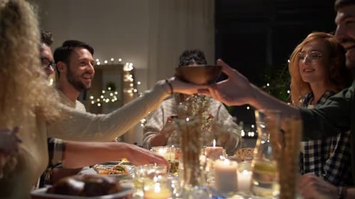 Friends Enjoying Candlelit Dinner Together Indoors at Night