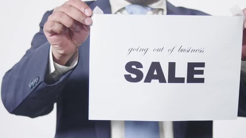 Man Holding Going Out of Business Sale Sign