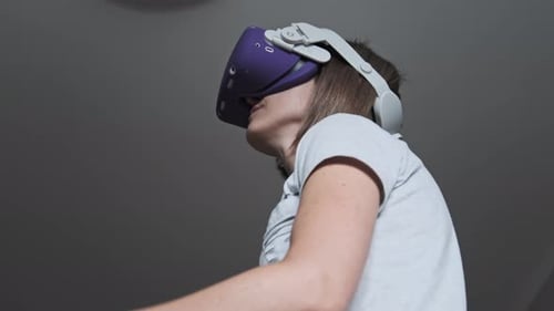 Woman Using Virtual Reality Headset and Controllers