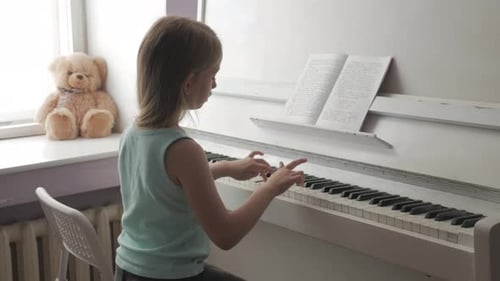 Child Playing Piano in a Bright Room