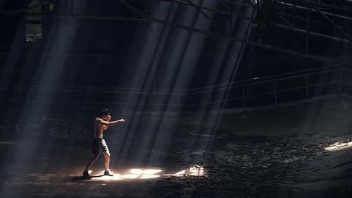 4K Asian man boxer practicing boxing exercise punching the air in abandoned building.