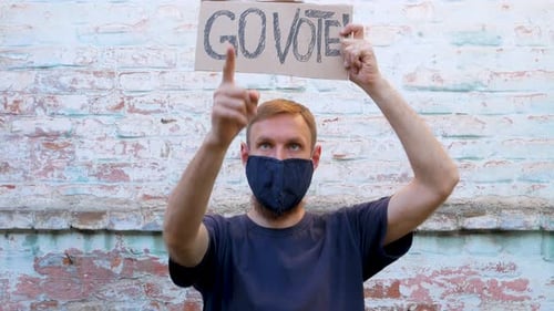 Man with Vote Sign Points at Camera