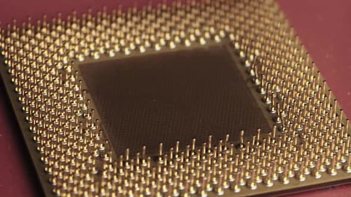 A antiga CPU de processador de computador com contatos banhados a ouro gira em fundo vermelho