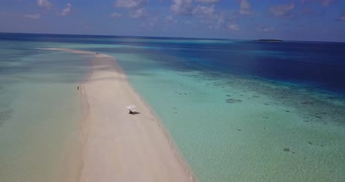Wide angle birds eye abstract shot of a sandy white paradise beach and blue sea background