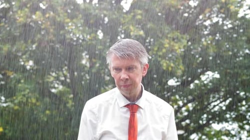 Man Stands in Rain Outdoors