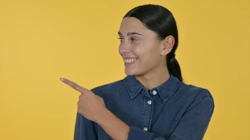 Smiling Woman Points to the Left on Yellow