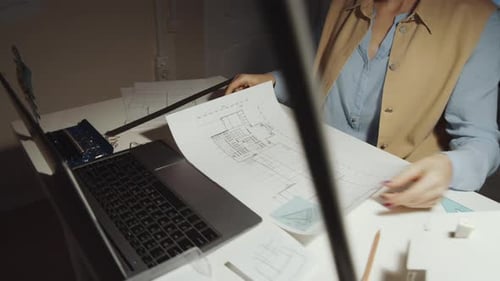 Architektin zeichnet Bauplan auf Papier am Schreibtisch