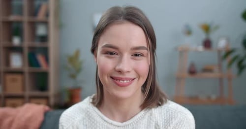 Close Up View of Millennial Woman Looking To Camera and Smiling. Portrait of Cheerful Young Female