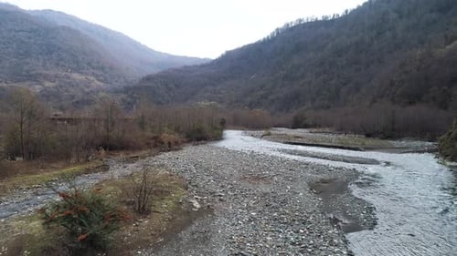 Montaña, río estrecho y costa pedregosa