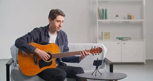 Man Plays Guitar While Filming