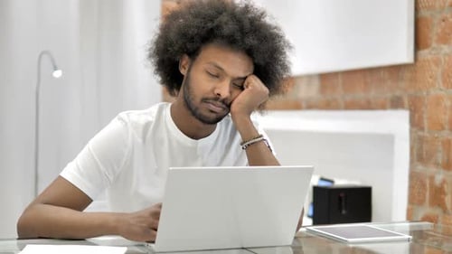 Man Sleeping at Desk with Laptop and Tablet